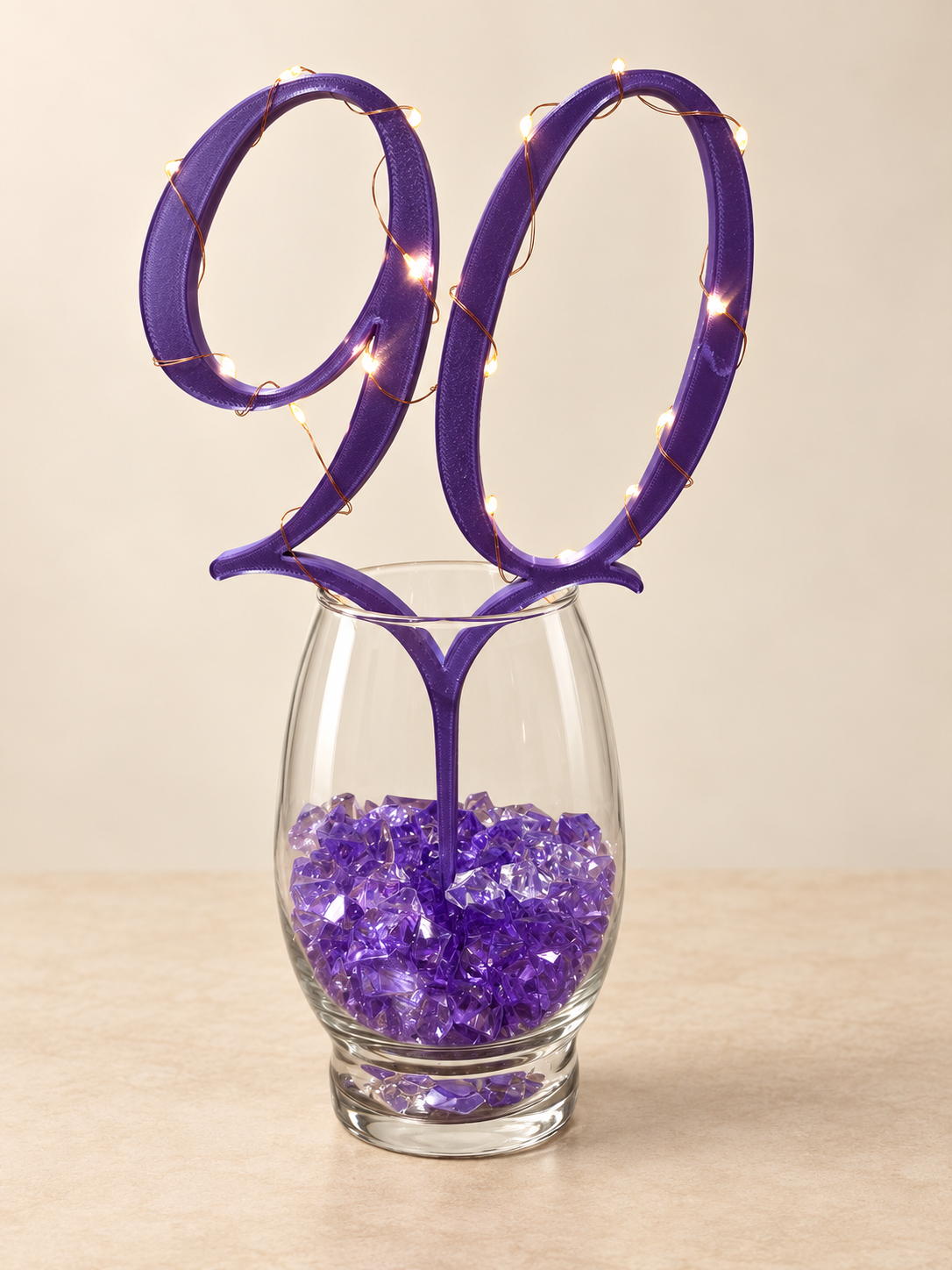 Purple number 90 centerpiece pick styled with fairy lights in a vase; lights and vase are not included
